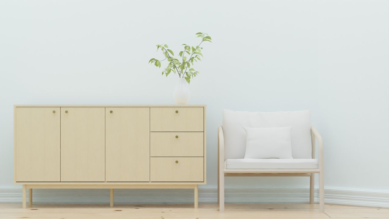 Home Elegant minimalist interior design featuring a wooden sideboard and armchair with greenery.